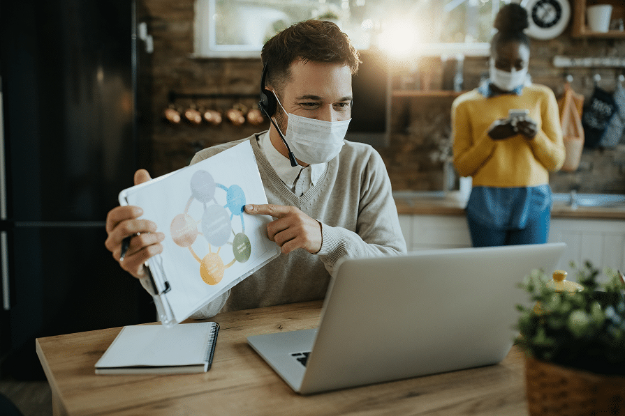 businesswoman-with-face-mask-analzying-paperwork-while-having-video-conference-desktop-pc-office-1